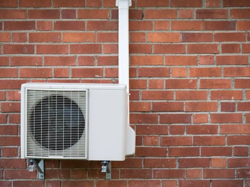 Heat pump installed on a brick wall