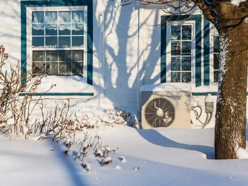 Heat pump outside of a house in snow