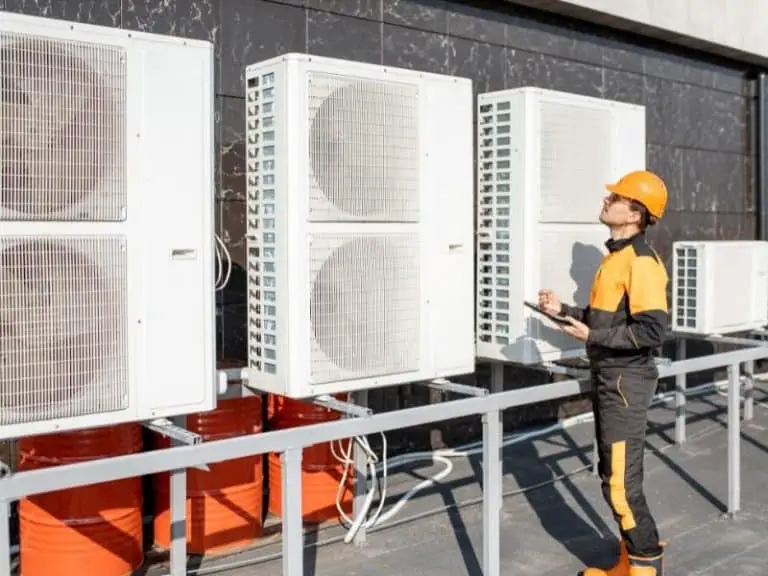 Heat pump units outside of a building engineer insepcting