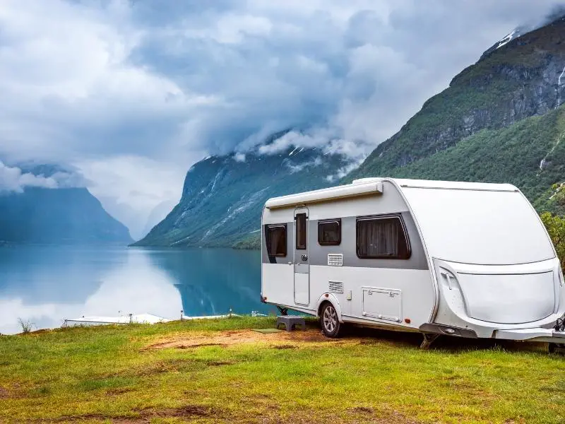 RV camper van next to a lake in the countryside