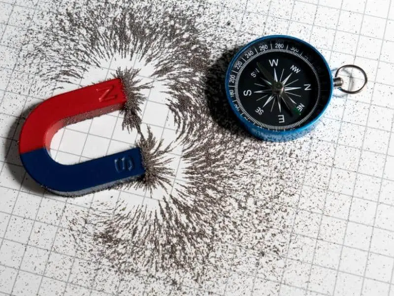 U magnet with metal shavings and a compass