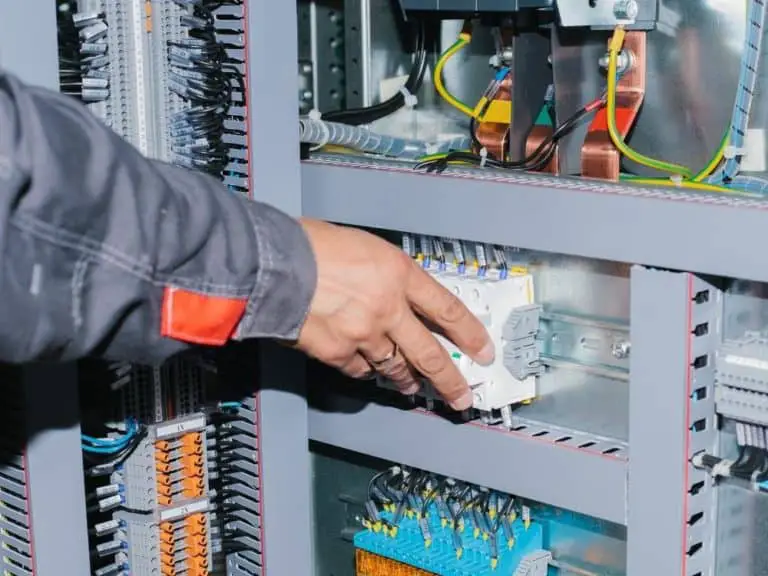 Electrician putting in fuses to a circuit meter