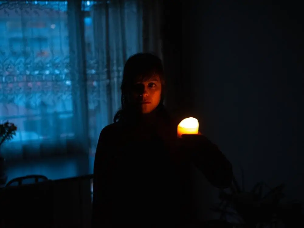 Woman holding a candle because the power is out