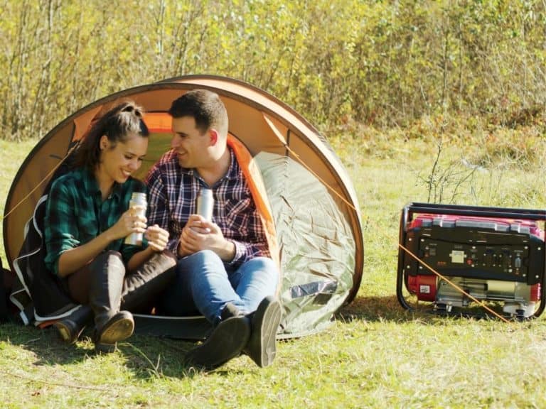 Couple camping with a generator outside on a hot day
