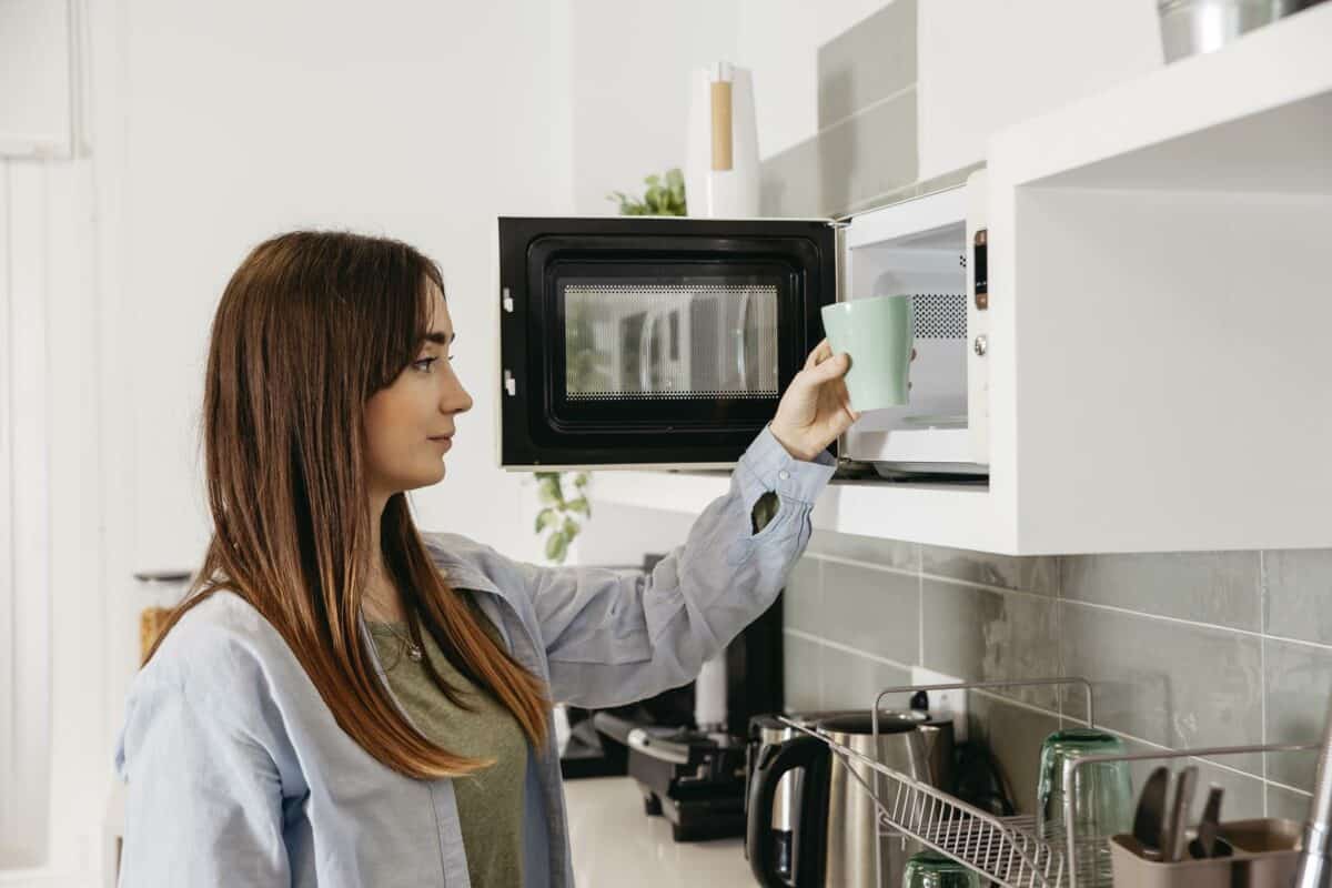 Woman using microwave heat cup.
