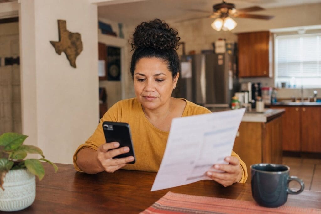 A Texas resident compares electricity payment options at a kitchen table.